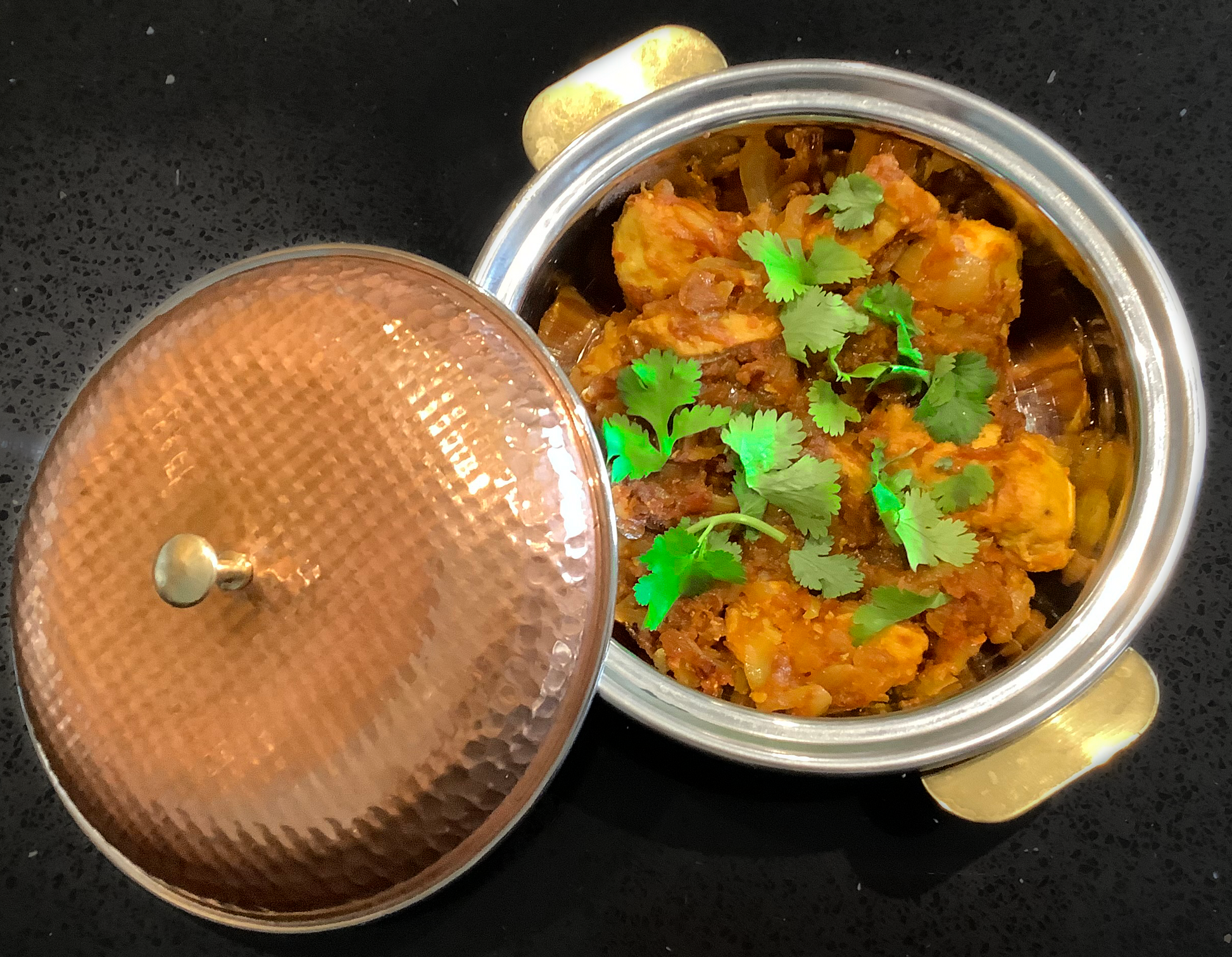 Aloo Gobi in a copper coloured metallic bowl.
