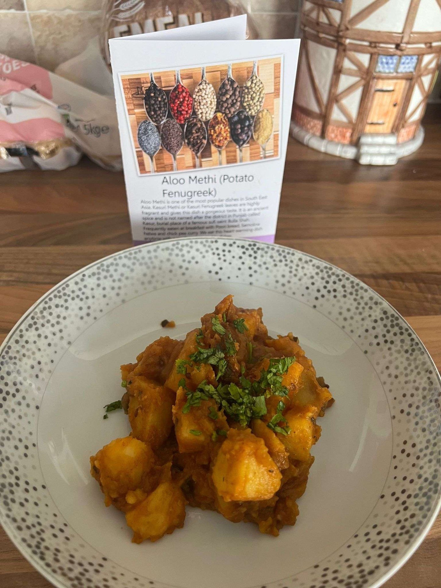 Aloo Methi in a white bowl with its recipe card in the background.
