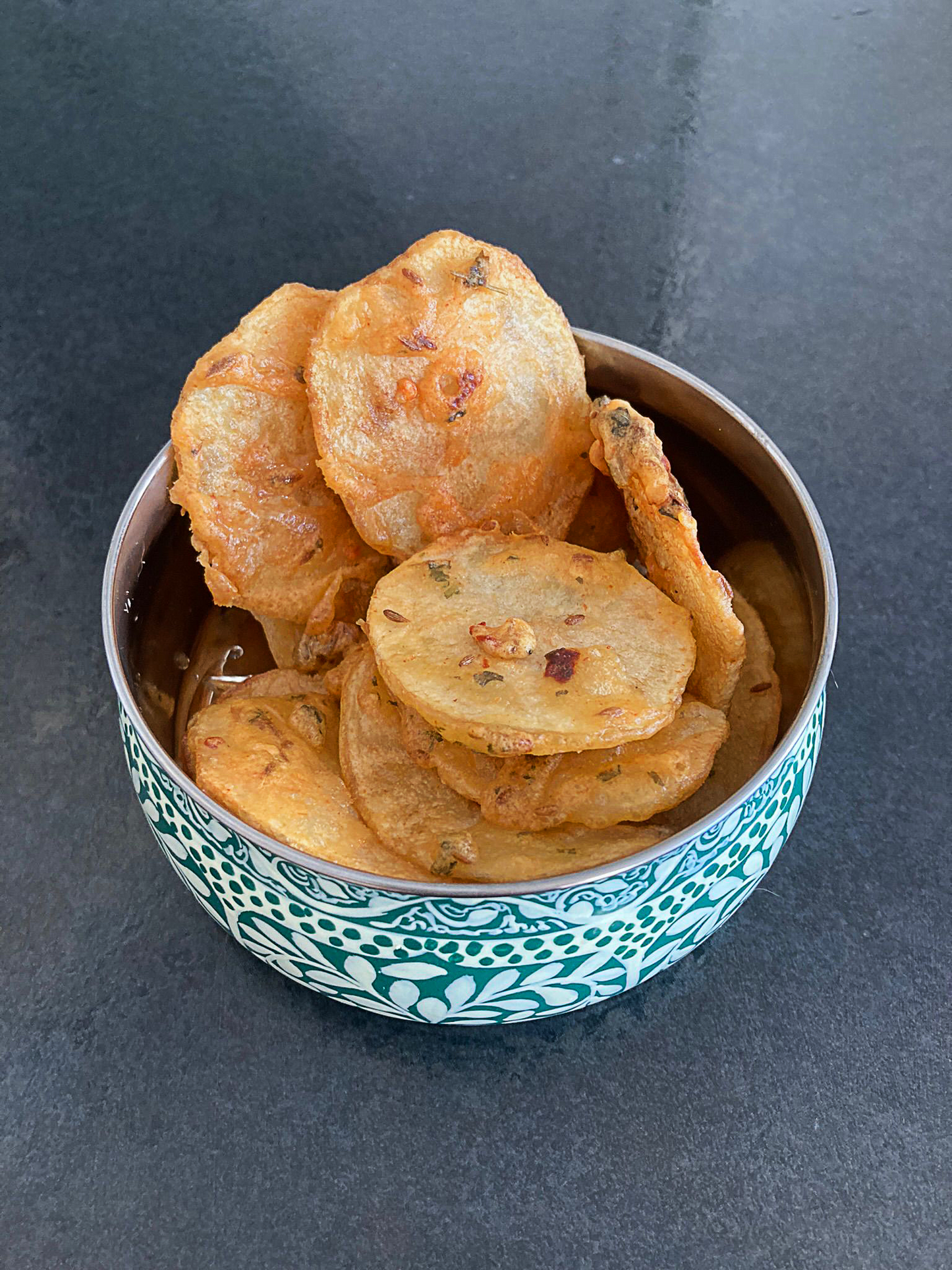 Photo of crispy potato bhajia in a blue bowl.