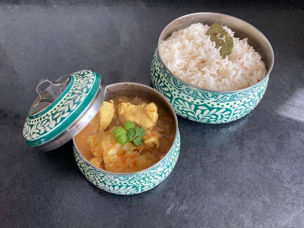 Doopiaza in a blue bowl next to plain rice in a similar bowl. 