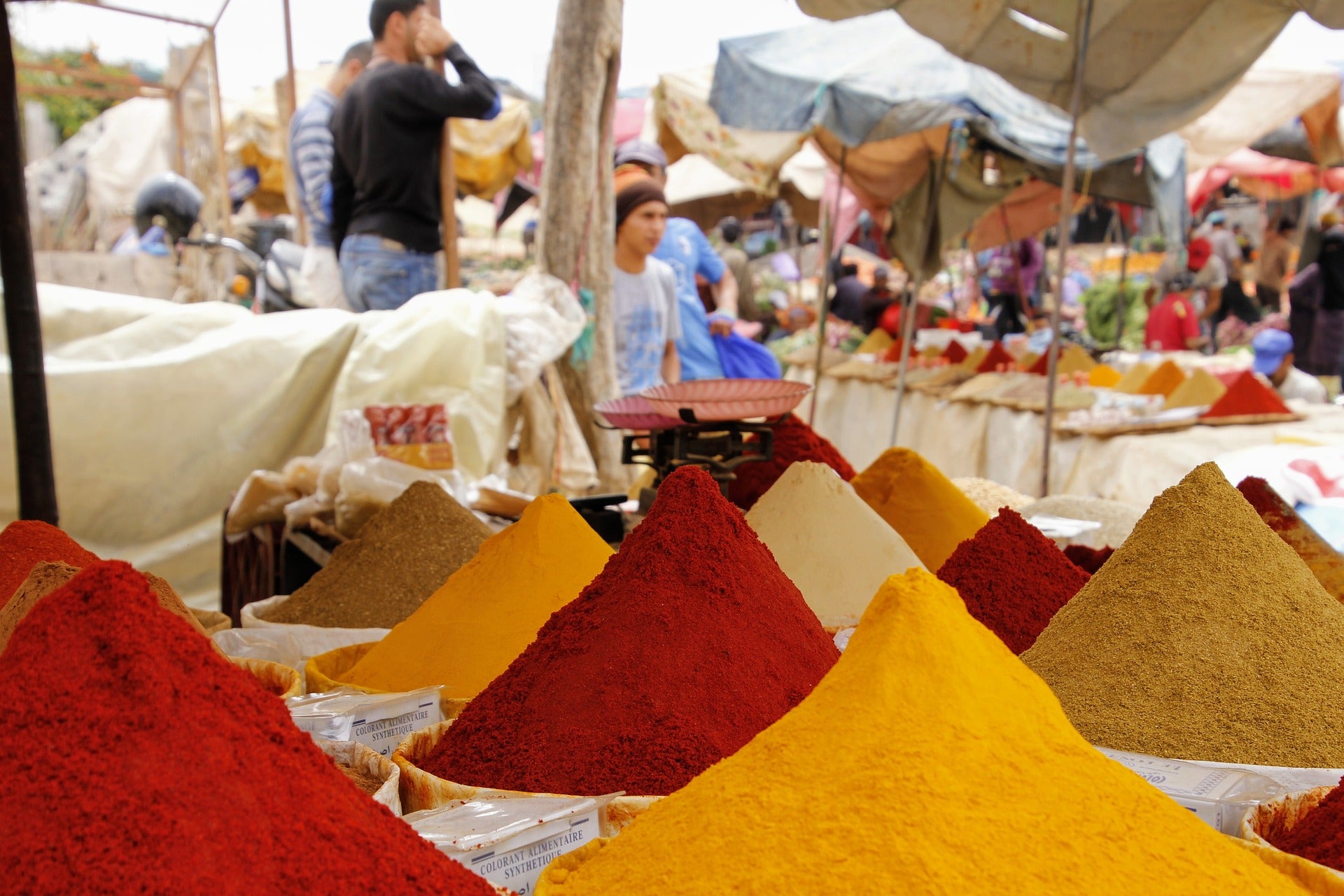 large piles of colourful spices in a market. 